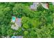 Aerial view showcases a property with a pool, lush landscaping, and winding driveway nestled among mature trees at 6220 E 56Th St, Indianapolis, IN 46226