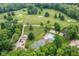 Aerial view featuring a community pool, tennis court, playground, and golf course, surrounded by mature trees at 6220 E 56Th St, Indianapolis, IN 46226