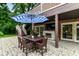 Charming outdoor patio with brick fireplace, TV, dining table with umbrella, and access to a staircase at 6220 E 56Th St, Indianapolis, IN 46226