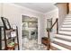 Inviting foyer featuring tile flooring, staircase, and kitchen view at 6220 E 56Th St, Indianapolis, IN 46226