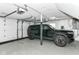 Clean and well-lit garage featuring a modern EV, epoxy flooring, and overhead storage for efficient organization at 6220 E 56Th St, Indianapolis, IN 46226