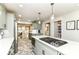 Bright, renovated kitchen with stainless steel appliances, shaker cabinets, brick accents, and cooktop island at 6220 E 56Th St, Indianapolis, IN 46226