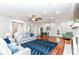 Bright living room with hardwood floors, fireplace, ceiling fan, light gray sofas and a blue rug at 6220 E 56Th St, Indianapolis, IN 46226