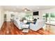 Bright living room with hardwood floors, white brick fireplace, ceiling fan and light gray sofas at 6220 E 56Th St, Indianapolis, IN 46226