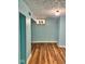Basement room with unique window, laminate floor, and fresh blue paint at 624 N Rural St, Indianapolis, IN 46201