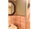 Bathroom featuring a large mirror, marble-tile wall, and a sink with a dark wood trim accent at 624 N Rural St, Indianapolis, IN 46201