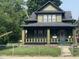 Charming two-story home featuring a covered front porch and a well-maintained yard at 624 N Rural St, Indianapolis, IN 46201