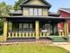 Two-story home with covered porch and decorative columns with green lawn at 624 N Rural St, Indianapolis, IN 46201