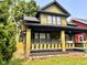 Two-story home with covered porch and decorative columns with green lawn at 624 N Rural St, Indianapolis, IN 46201