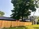 View of a two-story home with new fencing and mature trees at 624 N Rural St, Indianapolis, IN 46201