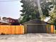 View of a detached one-car garage with a dark brown door and recently stained fence at 624 N Rural St, Indianapolis, IN 46201