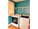 Bright laundry room with white, front-loading Maytag washer and dryer and open shelving above at 624 N Rural St, Indianapolis, IN 46201