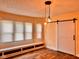Living room area featuring wood flooring, built-in bench, and a barn door at 624 N Rural St, Indianapolis, IN 46201