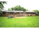 Expansive backyard with lush green lawn, brick patio, and the rear of the house, ideal for relaxation and entertainment at 6601 Twin Brooks Dr, Indianapolis, IN 46227