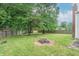 Spacious backyard with mature trees, fire pit and a well-maintained lawn, perfect for recreation at 6837 Littleton Dr, Indianapolis, IN 46221