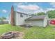 Home exterior with patio and outdoor seating area, surrounded by green lawn and mature landscaping at 6837 Littleton Dr, Indianapolis, IN 46221