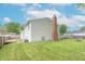 Exterior home view showing a brick chimney, yard, and partially visible deck and landscaping at 6837 Littleton Dr, Indianapolis, IN 46221
