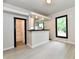Open-concept living room featuring stylish flooring and a serving hatch into the kitchen at 706 University Blvd, Anderson, IN 46012
