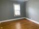 Cozy bedroom featuring hardwood floors, neutral paint, white trim, and a window with natural light at 730 N Riley Ave, Indianapolis, IN 46201