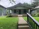 Charming craftsman home featuring a covered porch, walkway, and neatly maintained lawn with garden bed accents at 730 N Riley Ave, Indianapolis, IN 46201