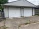 Detached two car garage featuring white doors and concrete driveway at 730 N Riley Ave, Indianapolis, IN 46201