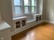 Bright living room featuring built-in cabinets with leaded glass and hardwood floors at 730 N Riley Ave, Indianapolis, IN 46201