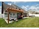 Large backyard featuring a patio, pergola, lounge area, and lush green lawn at 750 Trillium St, Lebanon, IN 46052
