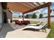 A covered patio with outdoor seating and lounge chairs overlooking the manicured backyard at 750 Trillium St, Lebanon, IN 46052