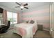 Cozy bedroom with gray and pink striped accent wall, ceiling fan, and neutral decor at 750 Trillium St, Lebanon, IN 46052