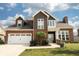 Charming two-story home with a brick and brown wood exterior and a manicured front lawn at 750 Trillium St, Lebanon, IN 46052