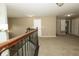 Upstairs hallway featuring neutral walls and carpeting with wood and iron railing at 750 Trillium St, Lebanon, IN 46052