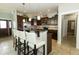 Open kitchen with island seating, stainless appliances, and dark wood cabinets at 750 Trillium St, Lebanon, IN 46052