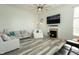 Bright living room with a fireplace, ceiling fan, and gray wood flooring at 750 Trillium St, Lebanon, IN 46052