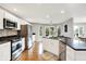Bright kitchen and breakfast nook with stainless steel appliances, granite counters, white cabinets, and backyard views at 826 N Lanyard Dr, Cicero, IN 46034