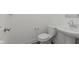 Compact half bath features a pedestal sink and toilet with neutral walls at 848 Holmdale Dr, Indianapolis, IN 46239