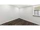 This bedroom features a window, dark hardwood floors, and white trim at 911 Eastern Ave, Indianapolis, IN 46201