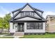 Charming two-story home with white and black accents, landscaped yard, and inviting curb appeal at 911 Eastern Ave, Indianapolis, IN 46201