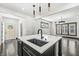 Kitchen island with stainless steel sink and pendant lights open to living room at 911 Eastern Ave, Indianapolis, IN 46201