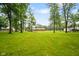 Sprawling backyard showcasing mature trees and a home with a deck under a blue sky at 9378 N County Road 75 W, Lizton, IN 46149