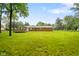 View of brick home with a deck nestled in a large, grassy backyard under a blue sky at 9378 N County Road 75 W, Lizton, IN 46149