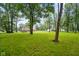 Lush backyard featuring a brick home with a deck, surrounded by mature trees at 9378 N County Road 75 W, Lizton, IN 46149