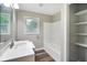 Well-lit bathroom featuring a shower-tub combination, modern vanity and storage shelves at 9378 N County Road 75 W, Lizton, IN 46149