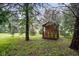 Cozy backyard playhouse with natural wood and a colorful fence nestled among the trees at 9378 N County Road 75 W, Lizton, IN 46149