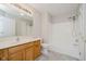 Well-lit bathroom features a wooden vanity, grey floors, combined tub and shower for a modern space at 9406 Avon Strand # Apt A, Avon, IN 46123