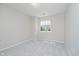 Empty bedroom with a gray carpet, neutral walls, a window with a view of foliage, and white trim at 9406 Avon Strand # Apt A, Avon, IN 46123
