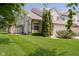 View of townhome with a well-maintained lawn and mature trees at 9406 Avon Strand # Apt A, Avon, IN 46123