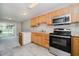 Bright kitchen with stainless steel microwave and oven range, light wood cabinets, and tile flooring at 9406 Avon Strand # Apt A, Avon, IN 46123