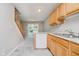 Kitchen with light wood cabinets, stainless steel sink, and dishwasher with a view of stairs and sliding doors at 9406 Avon Strand # Apt A, Avon, IN 46123