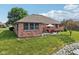 Brick home with a manicured lawn, rock-bordered pond, and backyard patio with outdoor furniture at 1027 Plum St # 39, Brownsburg, IN 46112