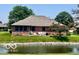 Picturesque backyard featuring a serene pond, lush green lawn, and the back of a brick house at 1027 Plum St # 39, Brownsburg, IN 46112
